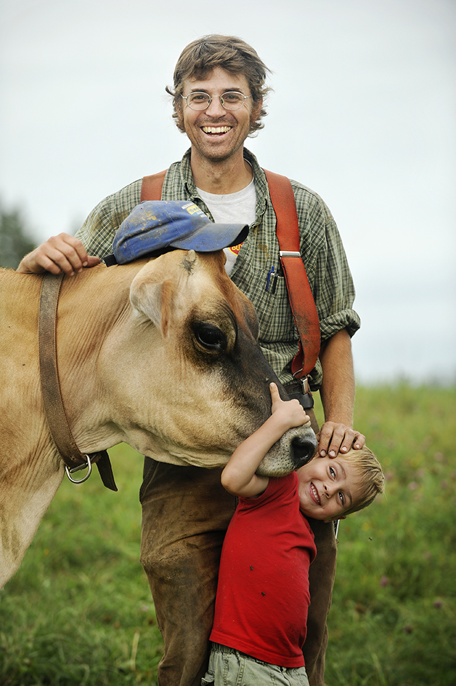 Dairy farmer with cow and son